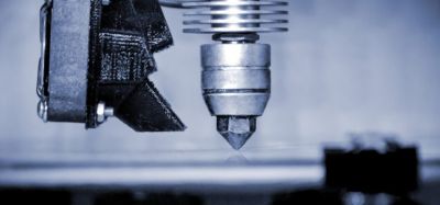 Close up of a 3D printing head about to start a print on the printing bed