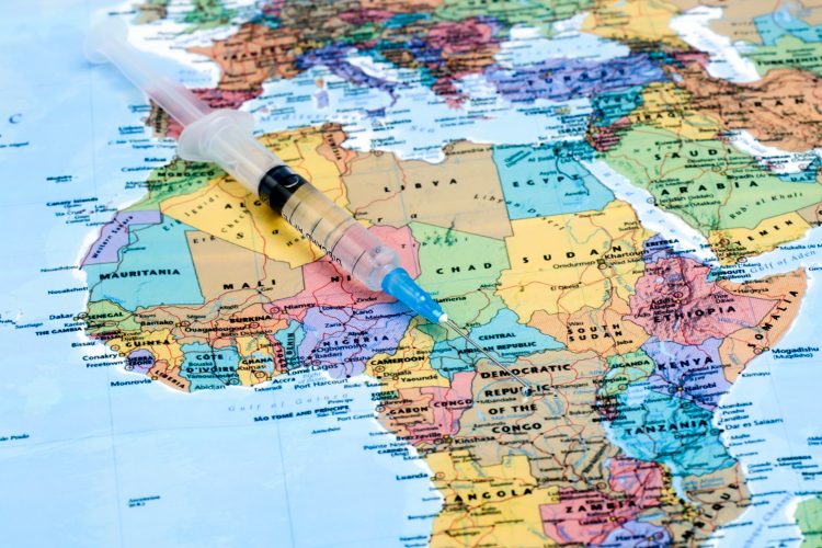 Syringe laid on a map of Africa - idea of vaccine distribution in Africa