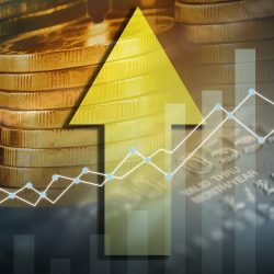 upwards yellow arrow overlaid on a stack of coins - idea of financial growth/gain