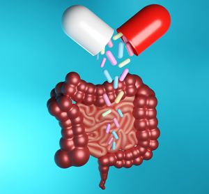 colourful bacteria pouring from an open capsule onto a cartoon small and large intestine - idea of delivering live biotherapeutic products