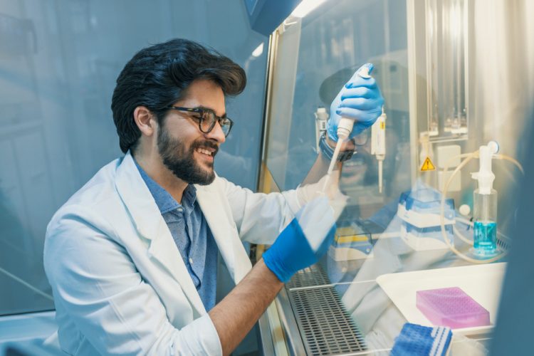 Scientist pipetting liquid in a Biological safety cabinet