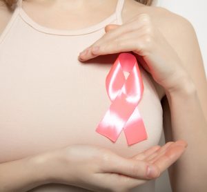 Pink ribbon on the girl’s chest - breast cancer