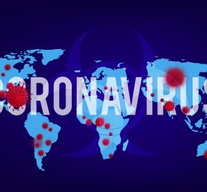 World map with countries is glowing light blue on a dark blue background, overlaid with word 'coronavirus' in white with red virus particles