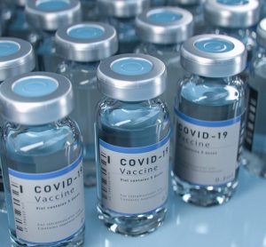 Vials labelled 'COVID-19 Vaccine' lined up in rows - idea of vaccine supply