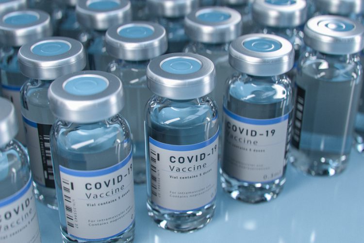 Vials labelled 'COVID-19 Vaccine' lined up in rows - idea of vaccine supply