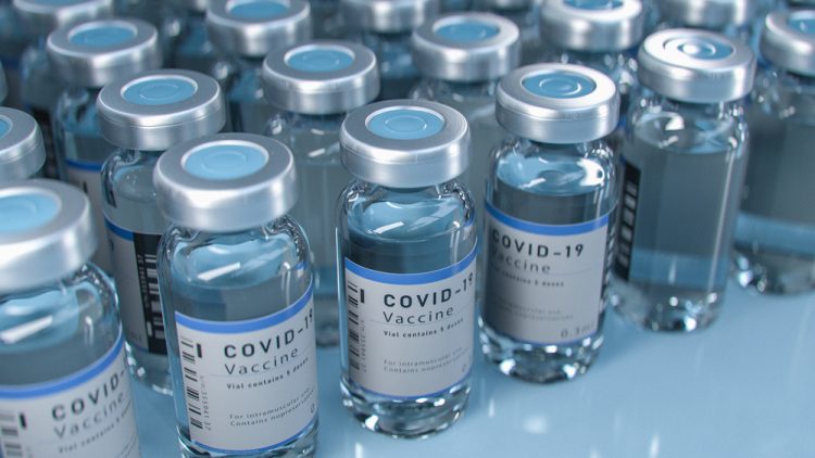 Vials labelled 'COVID-19 Vaccine' lined up in rows - idea of vaccine supply