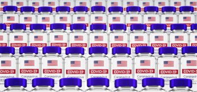 Vials labelled with the US flag and 'COVID-19 VACCINE) - idea of US vaccines/vaccine allocation