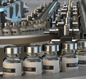 Vials labelled 'CORONAVIRUS VACCINE' on a production line - idea of COVID-19 vaccine manufacturing