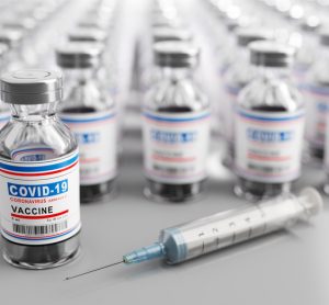 Lines of vials stretching off into the distance, all labelled 'COVID-19 Vaccine' - idea of COVID-19 vaccine supply/manufacturing