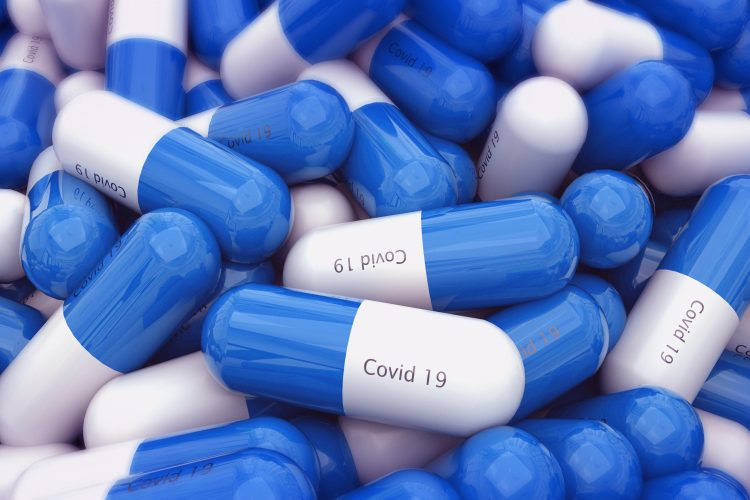 Blue and white capsules labelled 'COVID-19' - idea of tablet COVID-19 vaccine