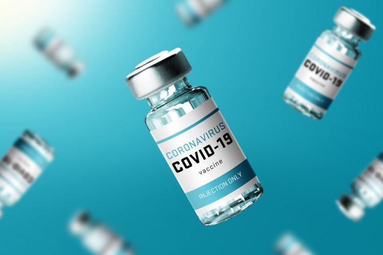 Glass vials labelled 'COVID-19 CORONAVIRUS VACCINE' falling in front of a turquoise background'