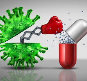 green coronavirus particle punching a medicine capsule (red and white) - idea of coronavirus not affected by antibiotics