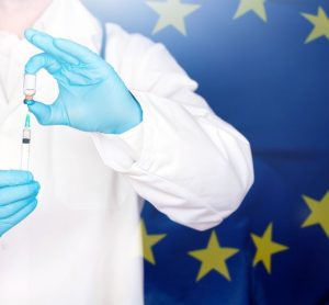 EU flag with doctor preparing for vaccine.
