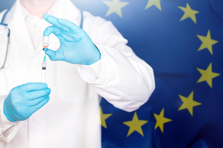 EU flag with doctor preparing for vaccine.