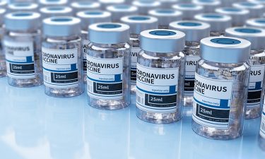 Vaccine vials labelled 'COVID-19 vaccine' lined up in rows