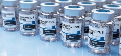 Vaccine vials labelled 'COVID-19 vaccine' lined up in rows
