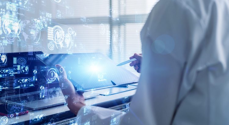 person in white lab coat operating a tablet