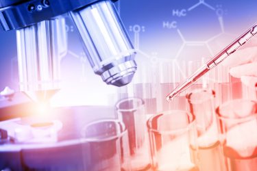 Close up of a microscope, chemical structure and test tubes next to each other - idea of medical/pharmaceutical research and development