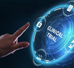 Hand reaching out toward a glowing circle labelled clinical trials -idea of digitalising clinical trials