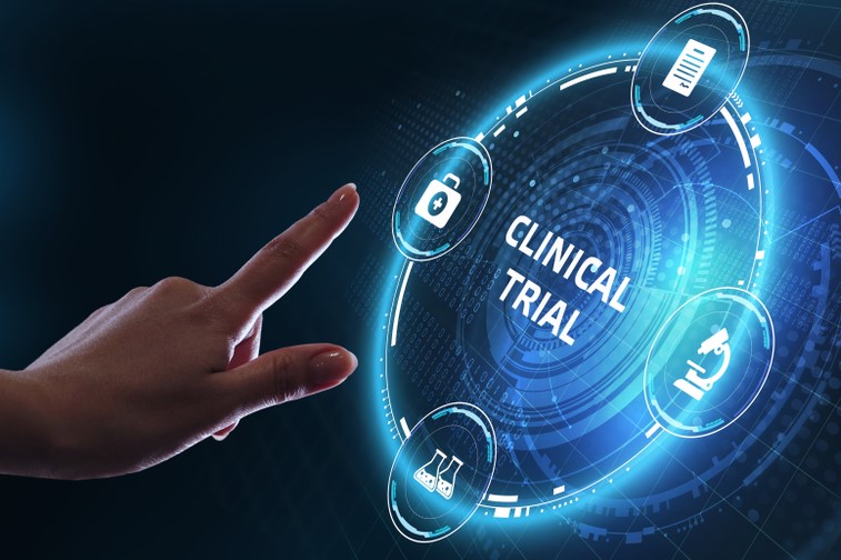 Hand reaching out toward a glowing circle labelled clinical trials -idea of digitalising clinical trials