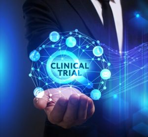 abstract clinical trials modernisation concept - business man holding a glowing orb containing the words 'Clinical Trial'