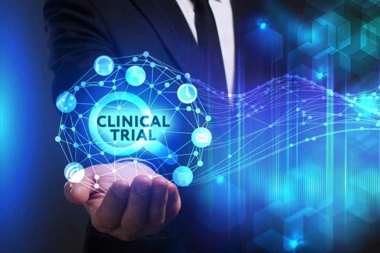 abstract clinical trials modernisation concept - business man holding a glowing orb containing the words 'Clinical Trial'