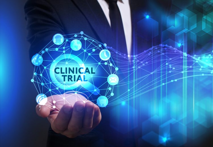 abstract clinical trials modernisation concept - business man holding a glowing orb containing the words 'Clinical Trial'