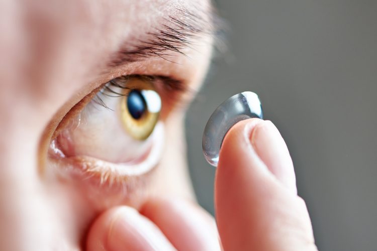 Close up of a person bringing a contact lens close to their eye