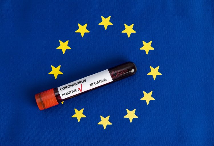 European Union flag (blue with circle of gold stars) with a blood vial on top labelled 'Coronavirus test, positive'