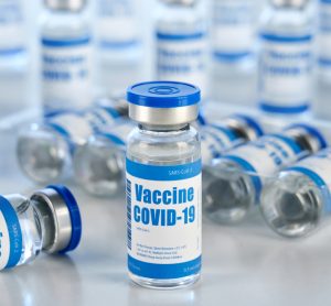 Vials with white and blue labels reading 'COVID-19 Vaccine'