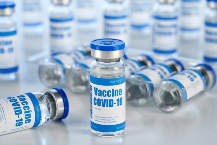 Vials with white and blue labels reading 'COVID-19 Vaccine'