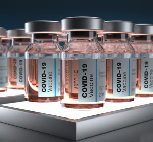 Lines of vials labelled 'COVID-19 Vaccines' [Credit: Dimitris Barletis/Shutterstock.com].