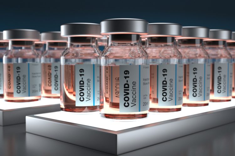 Lines of vials labelled 'COVID-19 Vaccines' [Credit: Dimitris Barletis/Shutterstock.com].