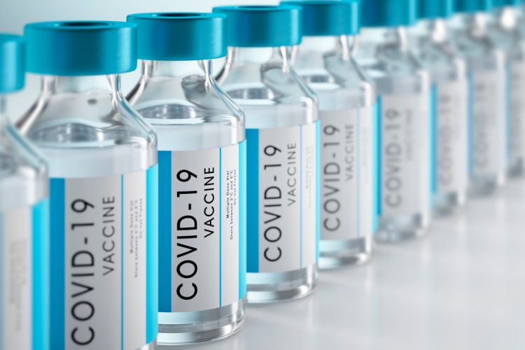 3D illustration of vials labelled 'COVID-19 Vaccine' in a row