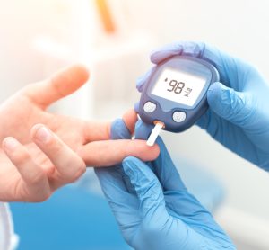 Diabetes patient's blood glucose level being checked by doctor