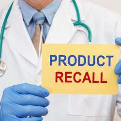 Doctor holding up a sign saying 'product recall'