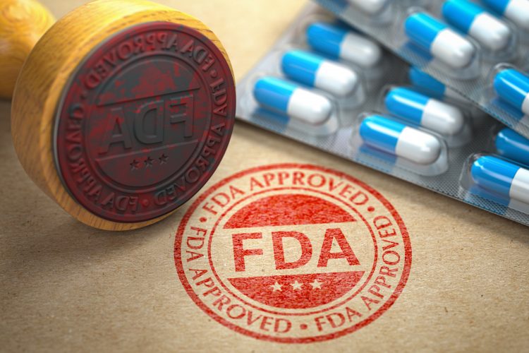 Stamp reading 'FDA APPROVED' next to a stack of blue and white capsules in blister packaging