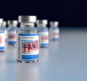 Vial labelled 'COVID-19 Vaccine' with red stamp over the top stating 'FAKE' - idea of counterfeit or falsified COVID-19 vaccines