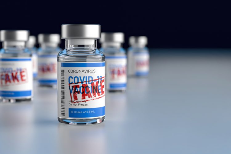 Vial labelled 'COVID-19 Vaccine' with red stamp over the top stating 'FAKE' - idea of counterfeit or falsified COVID-19 vaccines