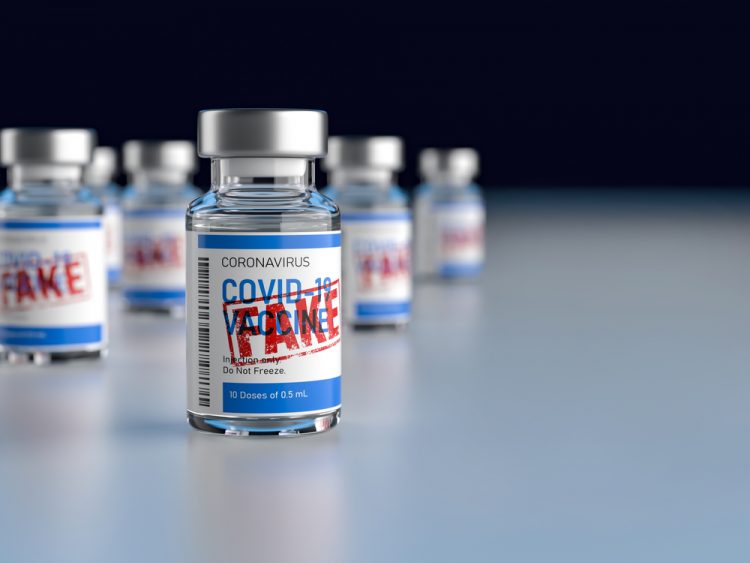 Vial labelled 'COVID-19 Vaccine' with red stamp over the top stating 'FAKE' - idea of counterfeit or falsified COVID-19 vaccines