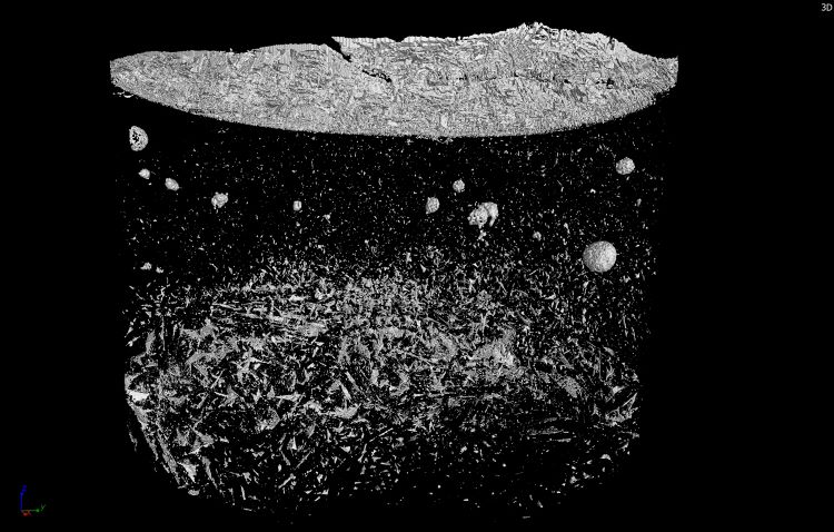 Figure 2: 3D reconstruction of a vial with 50 mg/mL mannitol formulation and added ethylene-propylene-diene rubber impurities. The impurities as well as a heterogeneous structure of the cake and the formed skin on top can be seen. Recorded and reconstructed by C. Schulbert (Geozentrum Nordbayern, Erlangen, Germany) in the Phoenix V|tome|x s (Waygate Technology, Hürth, Germany).