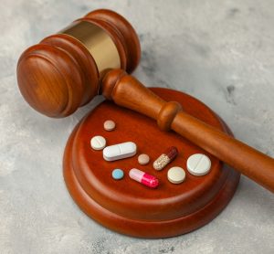 Wooden Judge's gavel and pills - idea of pharmaceutical regulations such as France's temporary authorisation (ATU) Programme