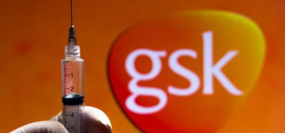 GSK logo (orange rounded corner inverted triangle with GSK lettering in white) with a gloved hand holding a syringe in front - idea of GSK vaccines