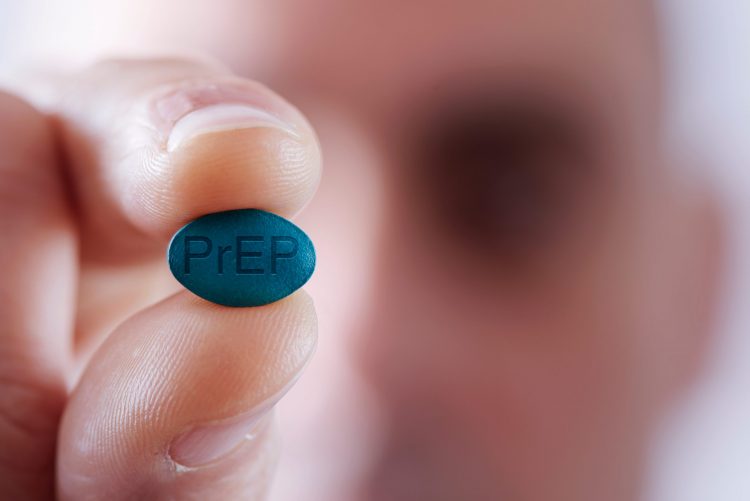 Man holding a blue tablet with 'PrEP' engraved on it
