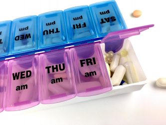 Pill box labelled with days of the week filled with medications - idea of HIV or other drug regimens