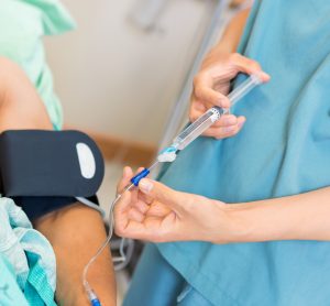 nurse administering an IV injection