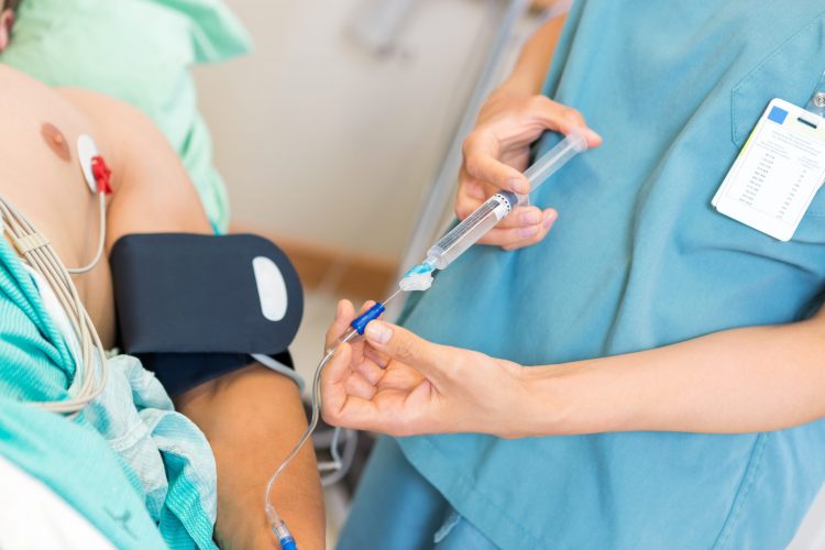 nurse administering an IV injection