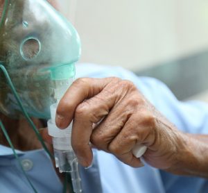 Elderly male patient wearing an oxygen mask - idea of respiratory distress/inhaled drug delivery