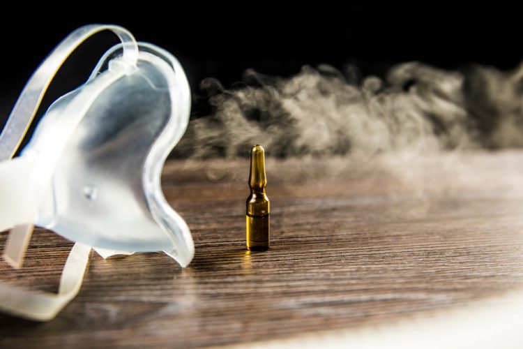 mist coming from a nebuliser surrounding a brown vial - idea of inhaled treatment or vaccine