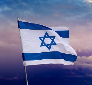 Israeli flag with blue star of David over Jerusalem on cloudy sky sunset background